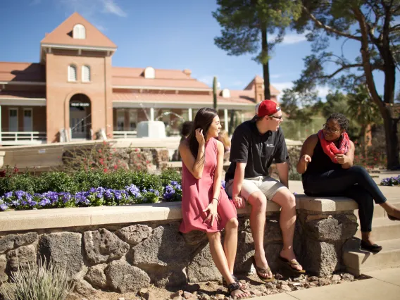 A group of students speaking with each other in front of Old Main