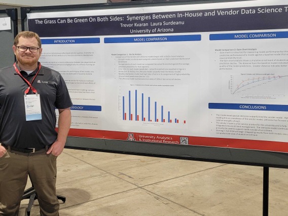 Data Scientist Trevor Kvaran standing in front of his poster at Educause 2023 Annual Conference