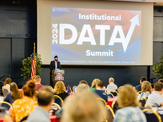 Ravneet Chadha at a podium speaking to attendees of the 2024 Data Summit