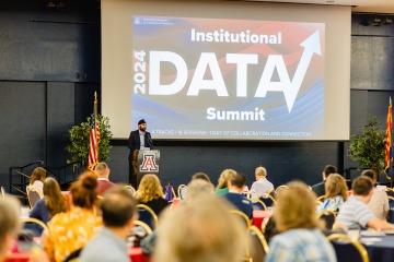 Ravneet Chadha at a podium speaking to attendees of the 2024 Data Summit